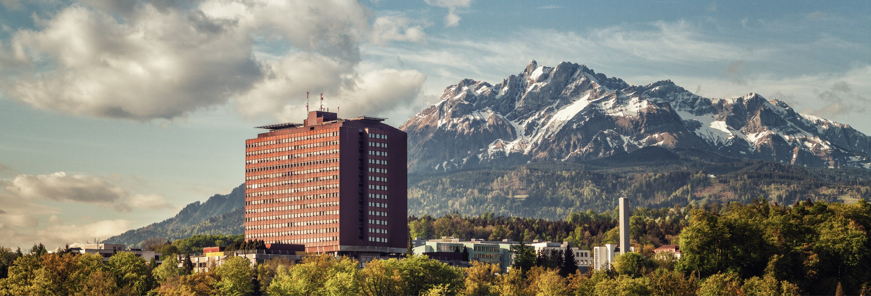 Auf diesem Bild sieht man das Kantonsspital in Luzern. Dahinter sind die Schweizer Alpen ersichtlich. HOGALOG arbeitet bereits seit mehreren Jahren mit dem Kantonsspital in Luzern und den gesamten Einkaufsprozess digitalisiert. 